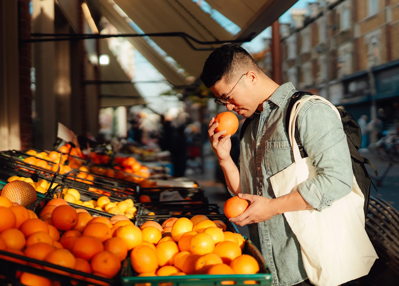 Man selecting fresh oranges at an outdoor market